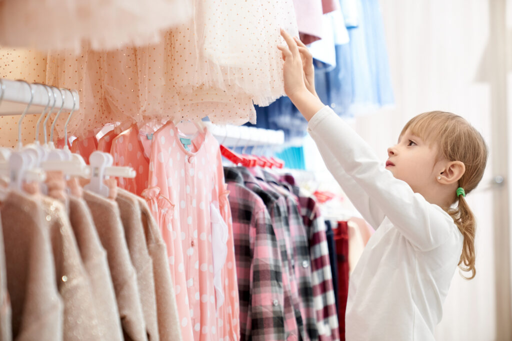 Niña escogiendo ropa infantil en la tienda MaLu